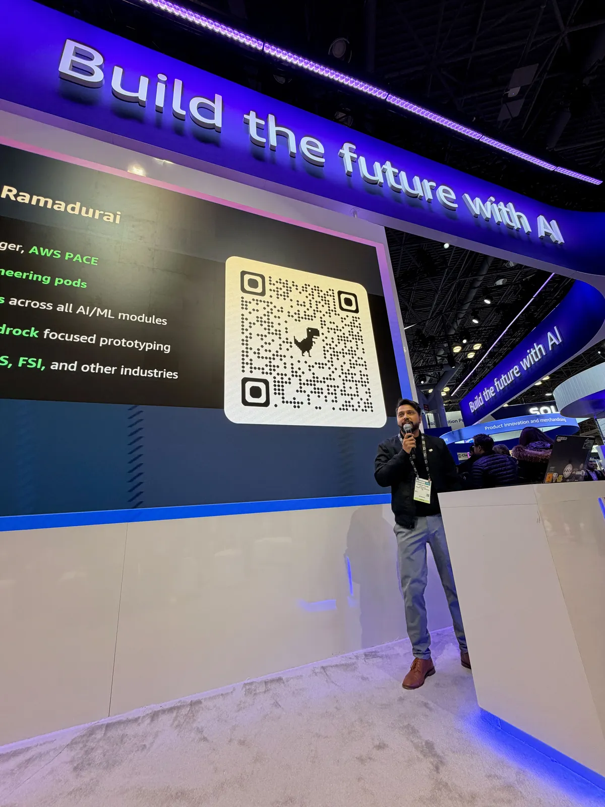 Ganesh Raam below his speaker slide at the AWS booth